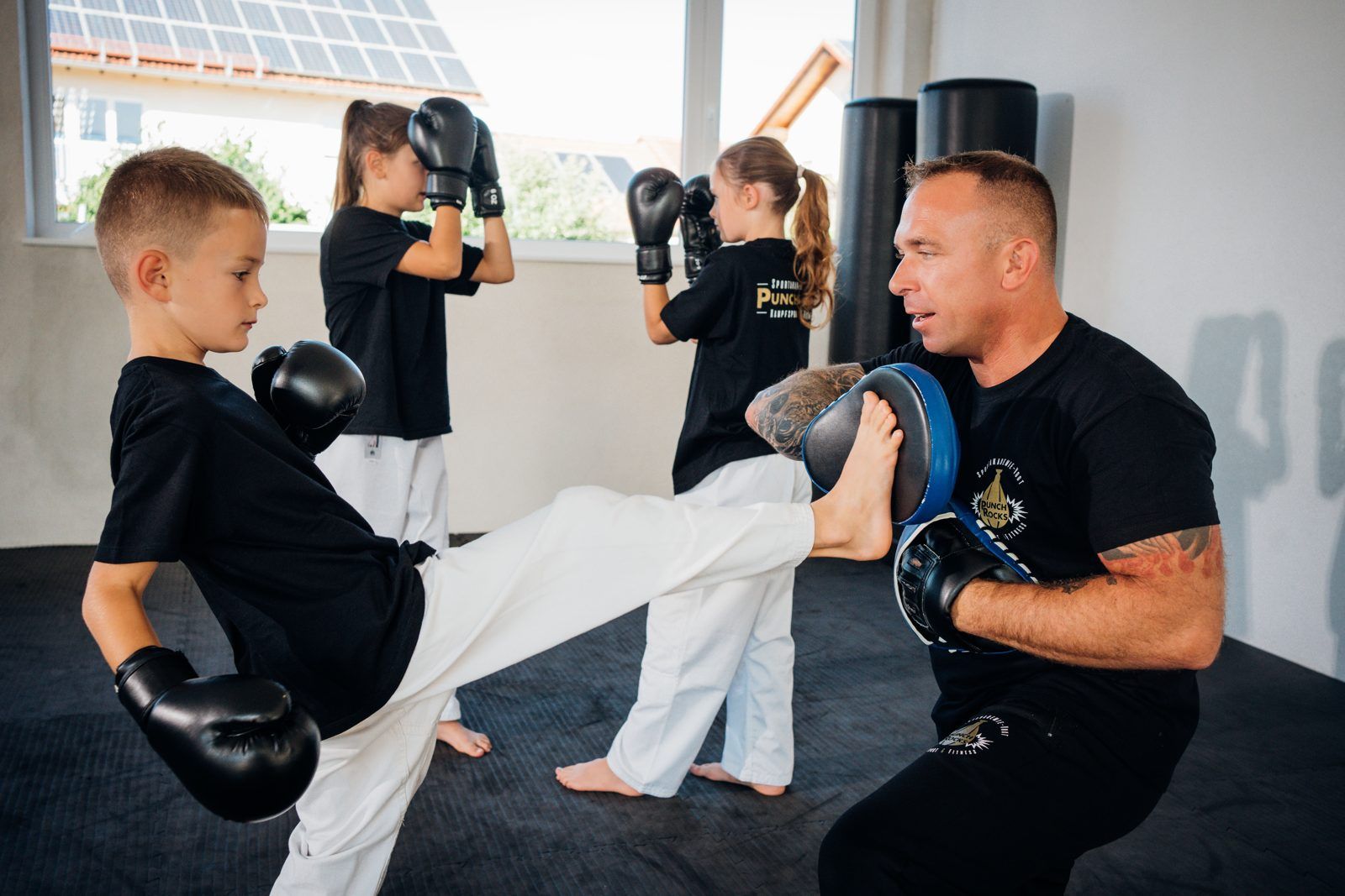 Kind beim Kick-Training an der Pratze